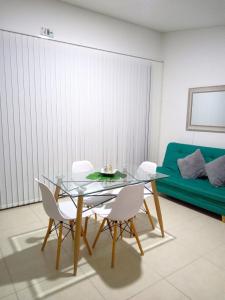 une salle à manger avec une table en verre et des chaises blanches dans l'établissement Apartasol Amor y Café, Reserva de la Colina, à La Tebaida