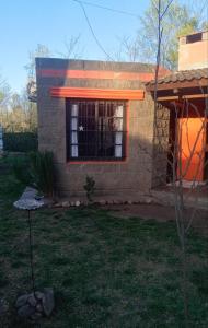 uma pequena casa com uma janela num quintal em La Casita del Río em Villa Ciudad Parque