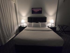 1 cama grande en una habitación de hotel con 2 lámparas en Borg El Thaghr Hotel en Alexandría