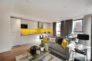 sala de estar con sofá y cocina en The Gatsby Luxury Apartment en Londres