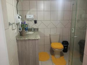 uma casa de banho com um WC, um lavatório e um chuveiro em Pousada da Alê em Blumenau