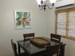 comedor con mesa de cristal y sillas en Ella's Park View Townhouse Crown Point en Crown Point