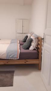 a bed with pillows on it in a room at La maison des créatifs in Montdardier