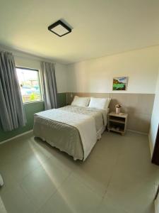 une chambre avec un grand lit et une fenêtre dans l'établissement Pousada Portal da Atalaia, à Fernando de Noronha