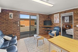 a living room with a brick wall at Kellraine Holiday Units in St Helens