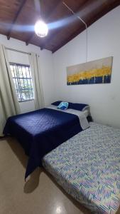 um quarto com uma cama azul e uma janela em Manila House El Poblado em Medellín