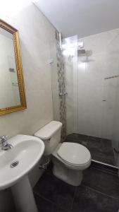 ein Badezimmer mit Toilette, Waschbecken und Spiegel in der Unterkunft Manila House El Poblado in Medellín