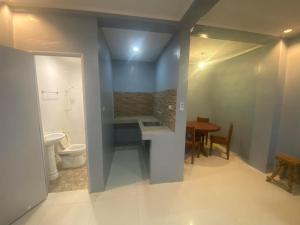a bathroom with a toilet and a sink and a table at Lakayo Hillside Apartelle in san juan la union