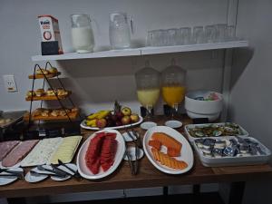 une table recouverte de assiettes de nourriture et de fruits dans l'établissement Quality Suites Vila Olimpia, à São Paulo