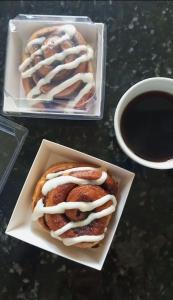 two pastries in a container next to a cup of coffee at Apartosuites en Sabana Grande in Caracas