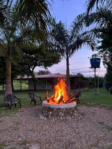 a fire pit in a park with two benches at RIOPARK BEACH HOTEL in Yopal