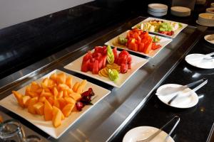 una línea de buffet con tres platos de frutas y hortalizas en Camino Real Pedregal Mexico, en Ciudad de México