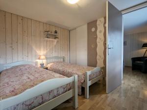 a bedroom with two beds and a sliding door at Charmant chalet de montagne avec terrasse et vue imprenable - FR-1-589-72 in Cornimont