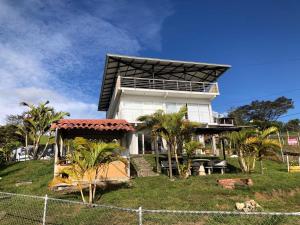 a large white house with palm trees in front of it at Lago calima cabaña in Darién