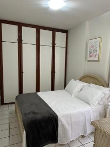 1 dormitorio con 1 cama grande con sábanas blancas en Flat praia Candeias, Piedade, en Recife