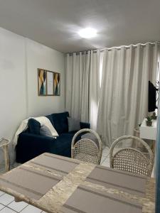 sala de estar con sofá azul y sillas en Flat praia Candeias, Piedade, en Recife