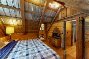 una camera con un grande letto in una cabina di legno di The Canopy House a Clinton