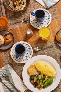 einen Tisch mit Teller mit Essen und zwei Tassen Kaffee in der Unterkunft Camino Real Zaashila Huatulco in Santa Cruz Huatulco