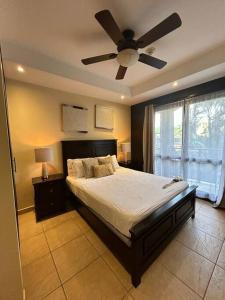 1 dormitorio con 1 cama y ventilador de techo en Apartamento de lujo frente a playa Jacó-3 BD/ 2 BA, en Jacó