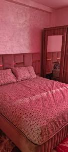 a bedroom with a large bed with a mirror at Résidence nahda in Agadir