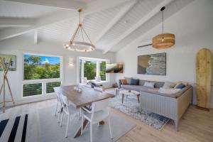 a living room with a table and a couch at Camp Magic 1 home in Hanalei