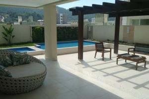 un patio con sofá y sillas en el techo en QUARTO privativo para 1 pessoa em Home Club, en Balneário Camboriú