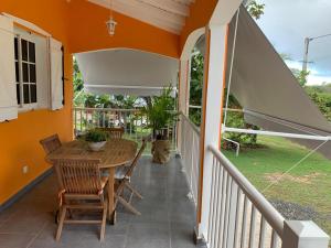 - une terrasse couverte avec une table, des chaises et un parasol dans l'établissement Studio La Félicité, à Le Moule