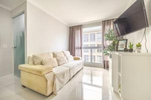 a living room with a couch and a television at QUARTO privativo para 1 pessoa em Home Club in Balneário Camboriú