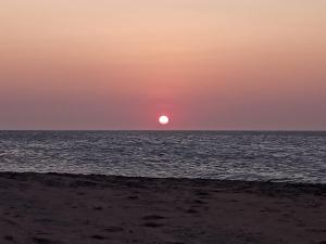 um pôr-do-sol sobre o oceano com o sol no horizonte em Casa do Bruno - Apartamento terreo - 1 - Terra - Quarto e sala com cozinha americana na praia do preá-CE em Prea