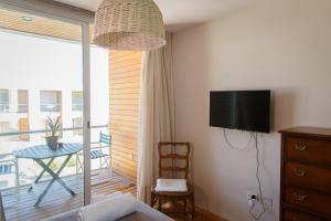 a room with a bed and a television and a table at Confortable loft deluxe con cochera en Yerba Buena in Yerba Buena