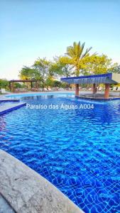 une piscine bleue avec conseiller aquarius aquarius de classe d'avitaillement dans l'établissement Guarajuba Paraíso das Águas A004, térreo - GUARAJUBA TEMPORADA, viva mais de uma experiência de hospedagem conosco!, à Guarajuba