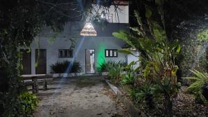 una casa de noche con luz verde en Residencial Maria de Lourdes, en Ibicoara