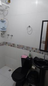 baño con aseo negro y lavamanos en Residencial Maria de Lourdes en Ibicoara