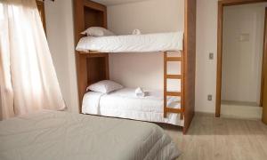 een slaapkamer met 2 stapelbedden en een ladder bij Apartamento Tomasini in Gramado