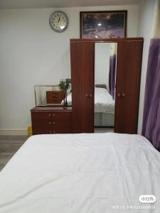 1 dormitorio con 1 cama, vestidor y reloj en Min Su Rooms en Stanwell