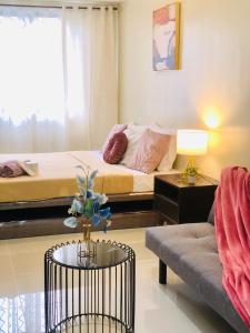 - un salon avec un lit et un canapé dans l'établissement PREMIUM CONDO AT BRENTHILL BAGUIO, à Baguio