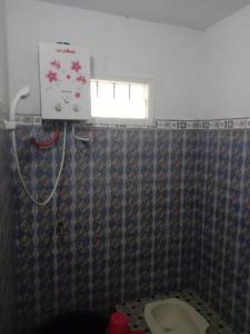 ein Bad mit einem Duschvorhang und einem WC in der Unterkunft Dedwa Homestay syariah in Batu