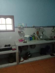 eine kleine Küche mit einer Theke und einem Fenster in der Unterkunft Dedwa Homestay syariah in Batu