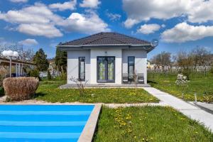 una pequeña casa con piscina en un patio en Holiday home in Ábrahamhegy - Balaton 42690, en Ábrahámhegy