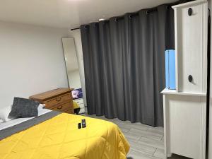 a bedroom with a yellow bed and gray curtains at SERENE FULL BED NEAR DOLPHIN MALL/FIU in Miami