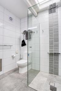 a bathroom with a toilet and a glass shower at Castle Creek Motel in Euroa