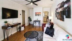 a living room with a white couch and a flat screen tv at Affordable, Walkable Near Forsyth Park Free Parking in Savannah