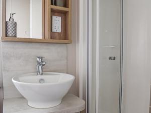 a bathroom with a white sink and a shower at Copse View in Kelsale