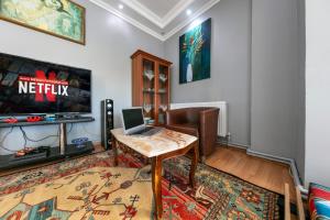 sala de estar con mesa y ordenador portátil. en See Suite en Estambul