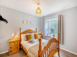 Holly Cottage في Clearwell: غرفة نوم بسرير خشبي ونافذة