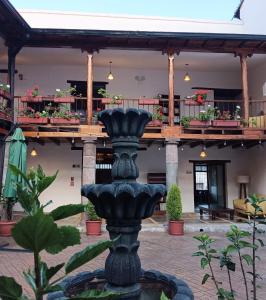 a black fountain in front of a building at Casona Tobar Hotel in Rocafuerte