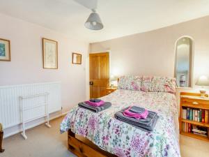 a bedroom with a bed with two towels on it at Old Orchard Cottage in Dilton