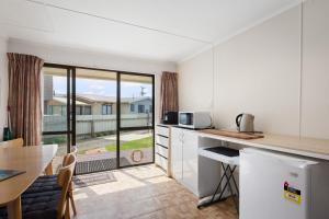 uma cozinha com um balcão e uma mesa com uma mesa em Waihi Beach B&B em Waihi Beach