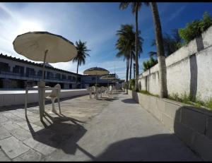 a row of chairs and umbrellas on a sidewalk at Pousada do Goiano in Cabo Frio