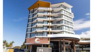 a tall building with a sign in front of it at Serenity at Solaris 101 in Forster